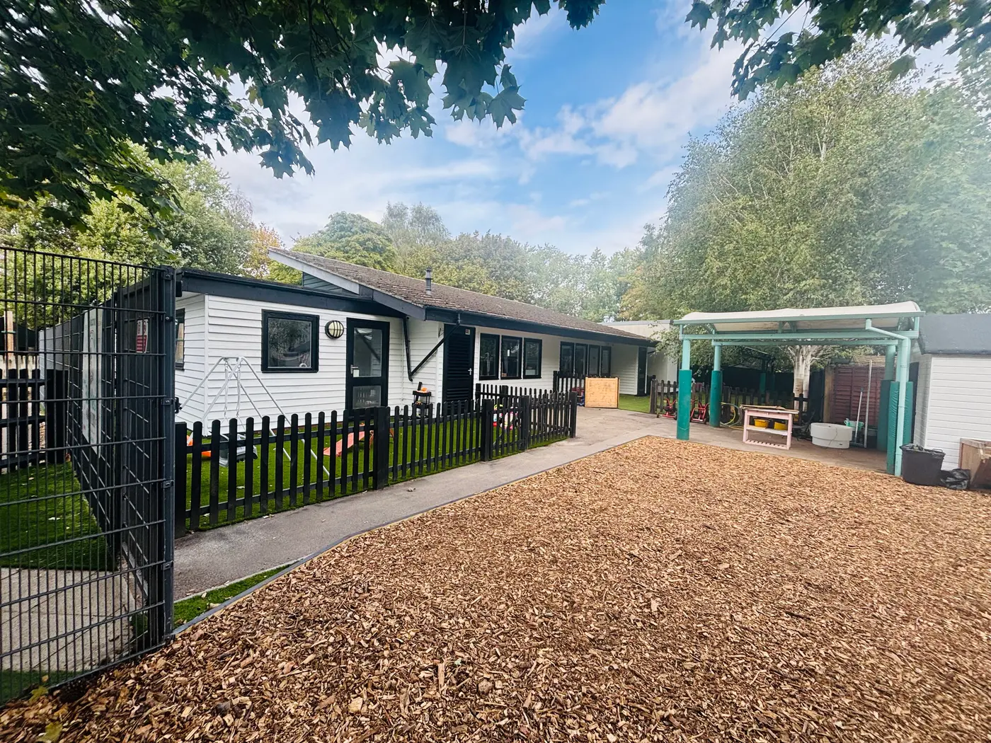 Blue Nest Montessori, Aldershot: the converted nursery building, covered walkway and bark play area completed by Ideas Capital